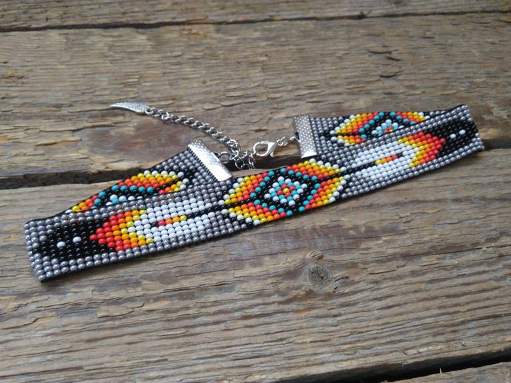 a beaded key chain is sitting on a wooden surface