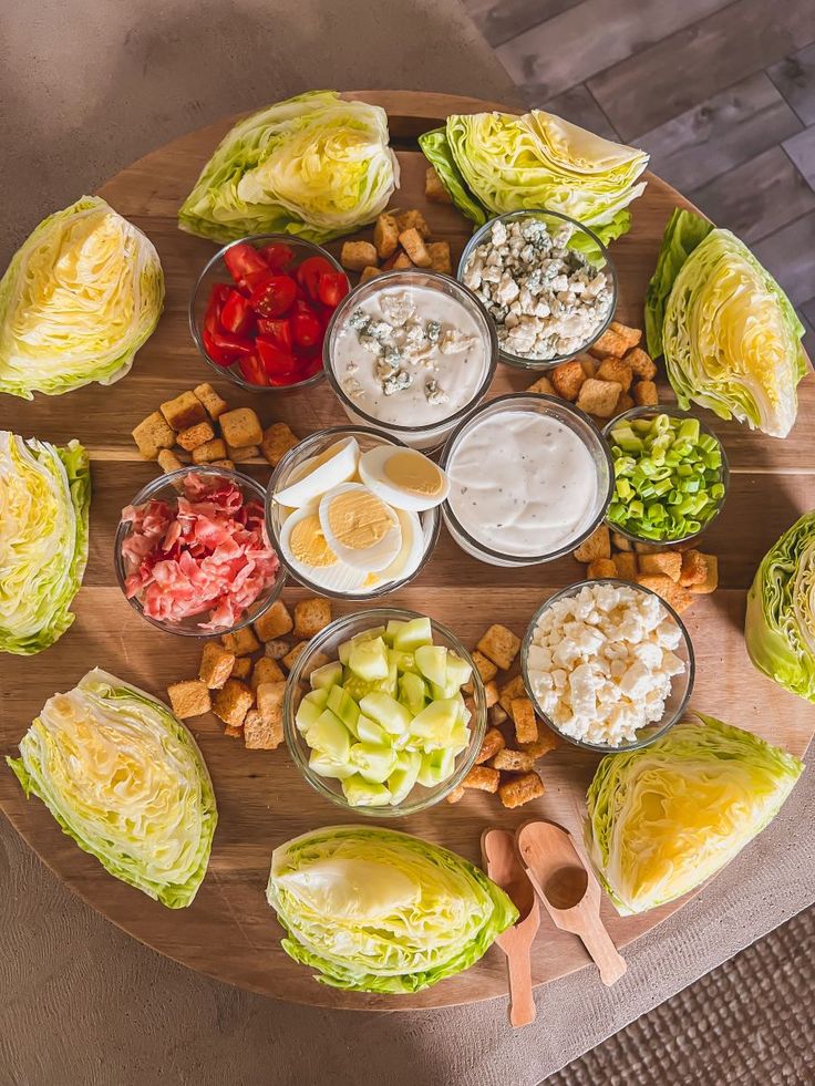 a wooden platter filled with lots of different types of food on top of a table