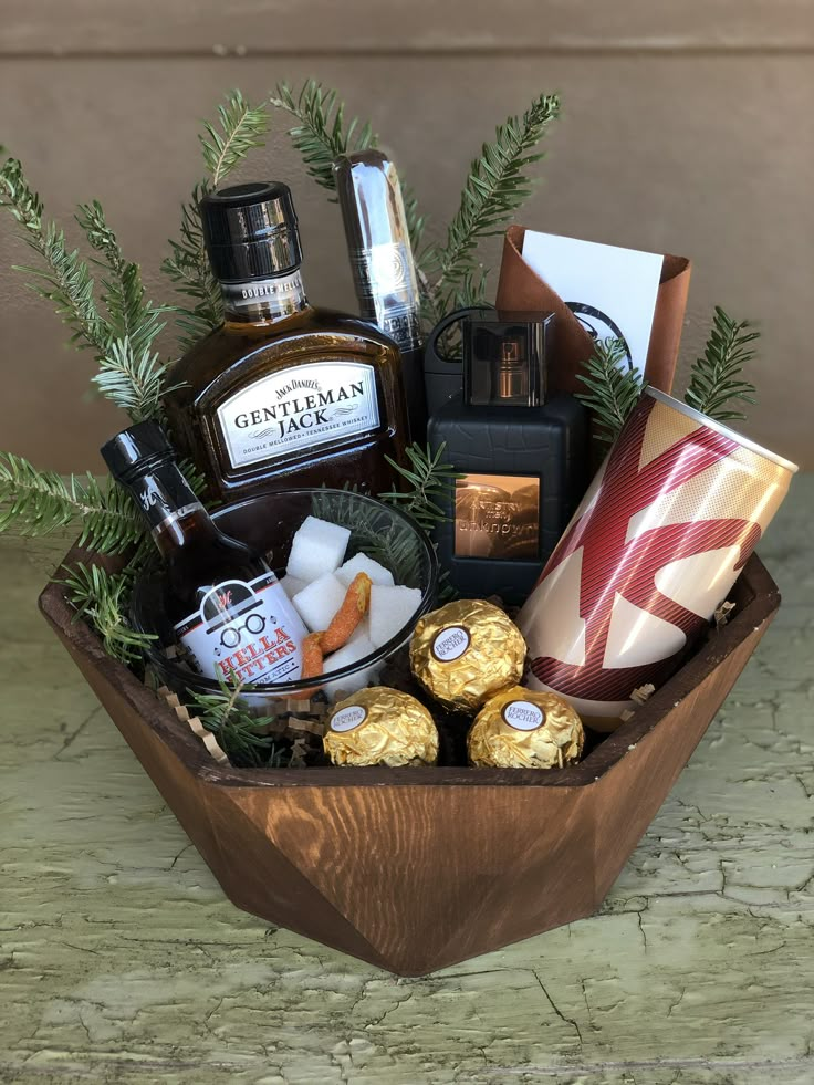 a wooden bowl filled with lots of different types of liquor and other holiday items on top of a table