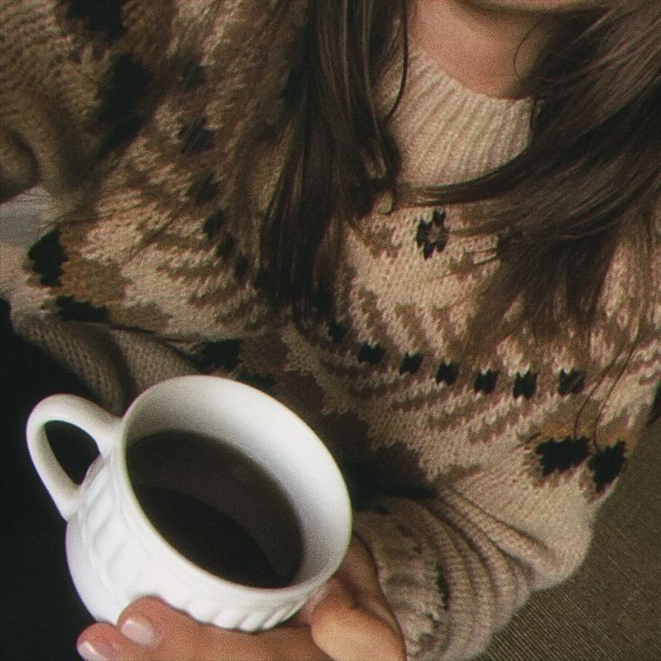 a woman holding a cup of coffee in her hands