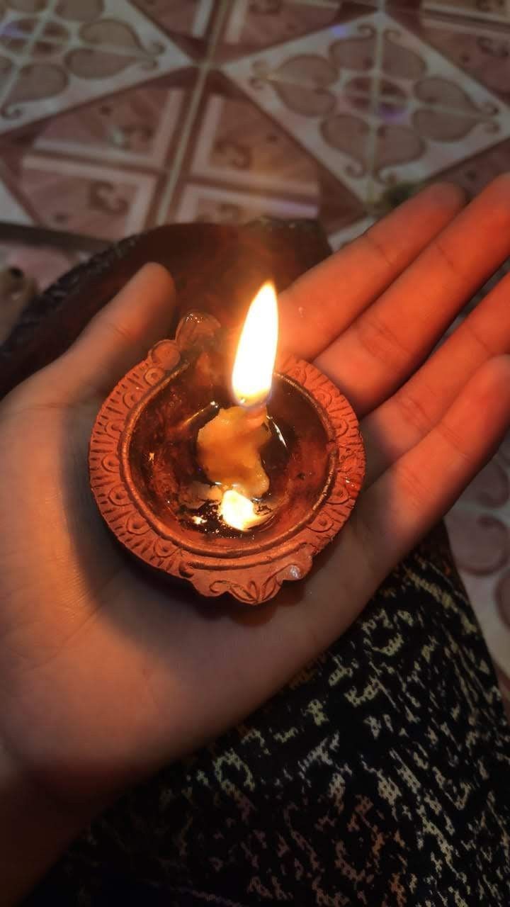 a person holding a lit candle in their hand