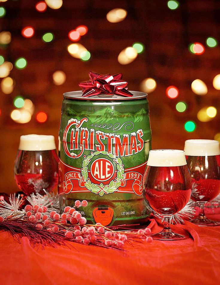 three empty wine glasses sitting on top of a table next to a tin can with christmas ale in it