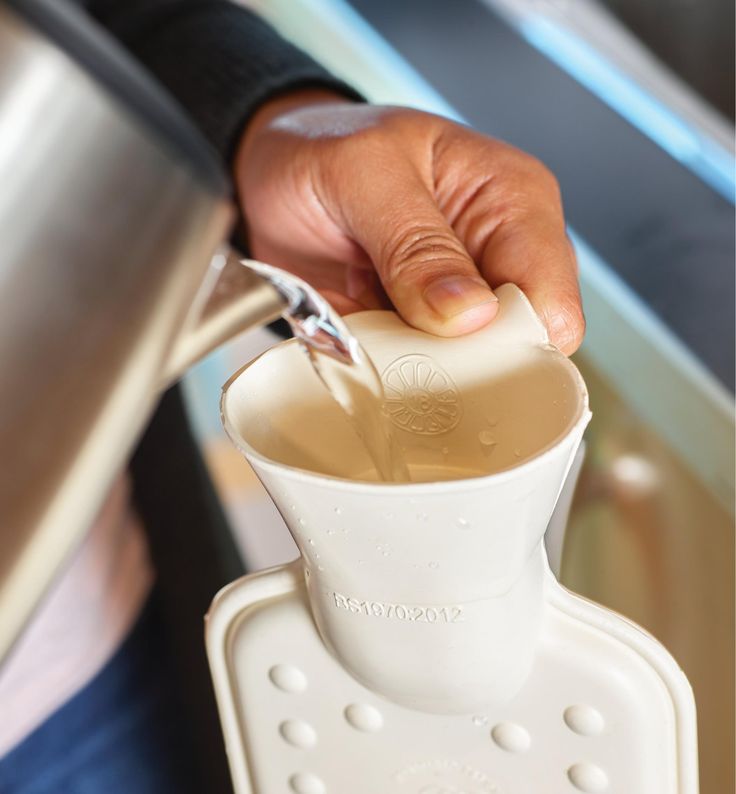 a person pouring something into a blender in their hand and holding it with one hand