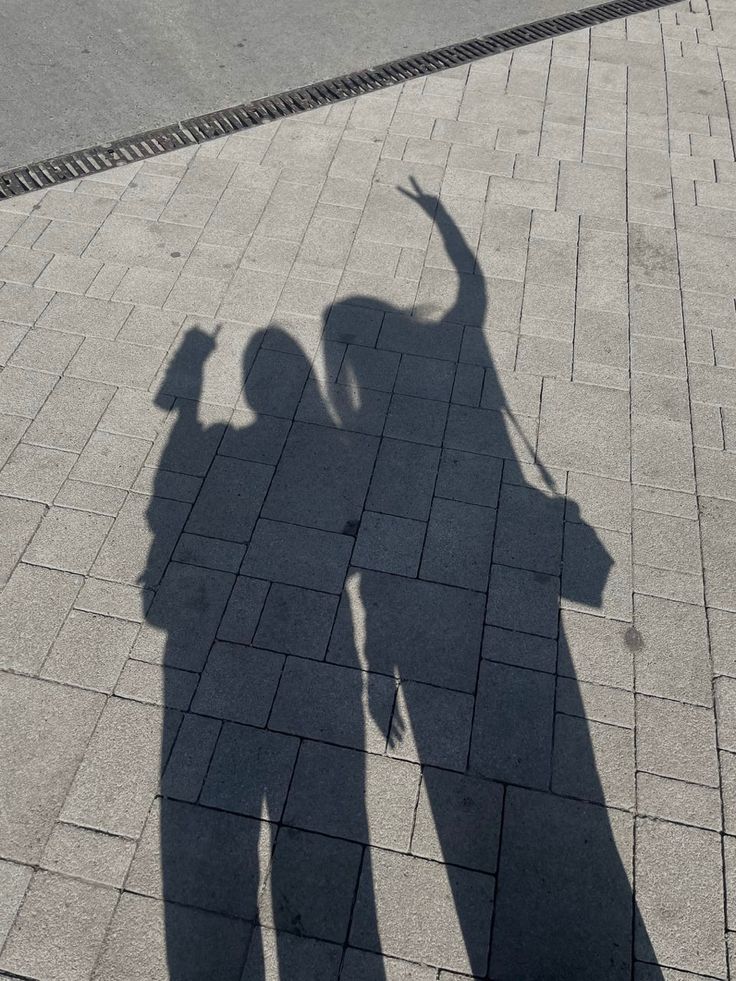 the shadow of two people standing next to each other