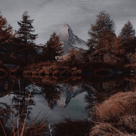 an image of a mountain reflected in the water