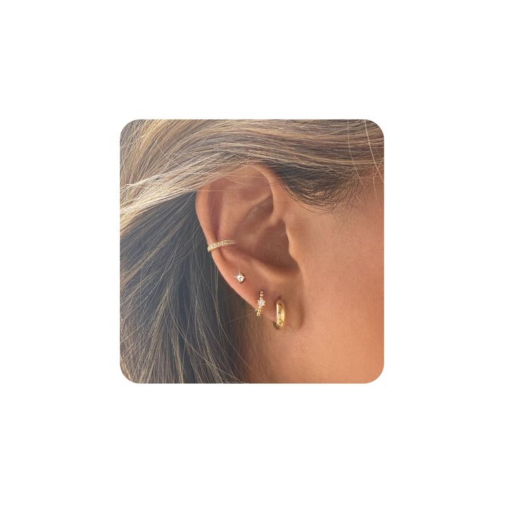 a woman's ear is shown with two small gold hoops on the side