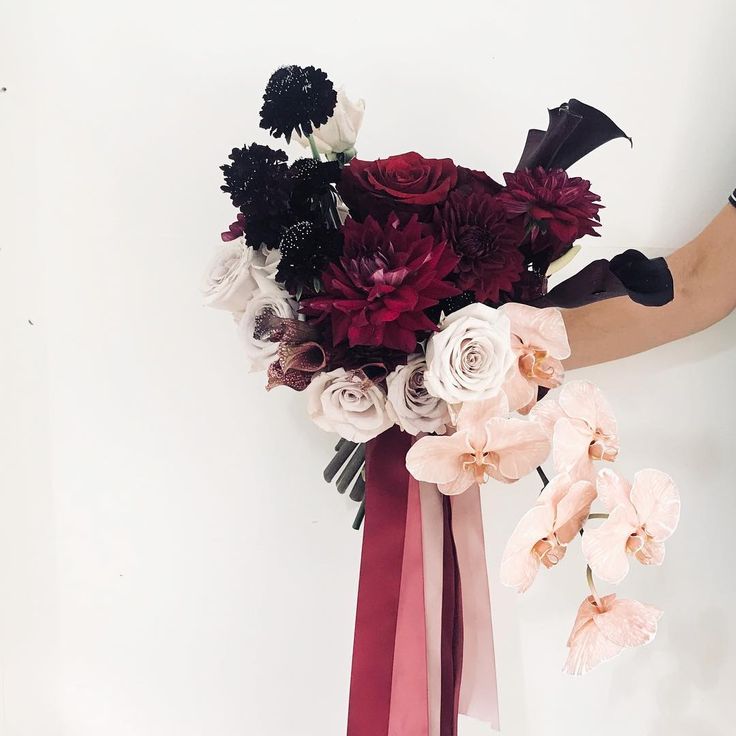 a woman holding a bouquet of flowers in her hands