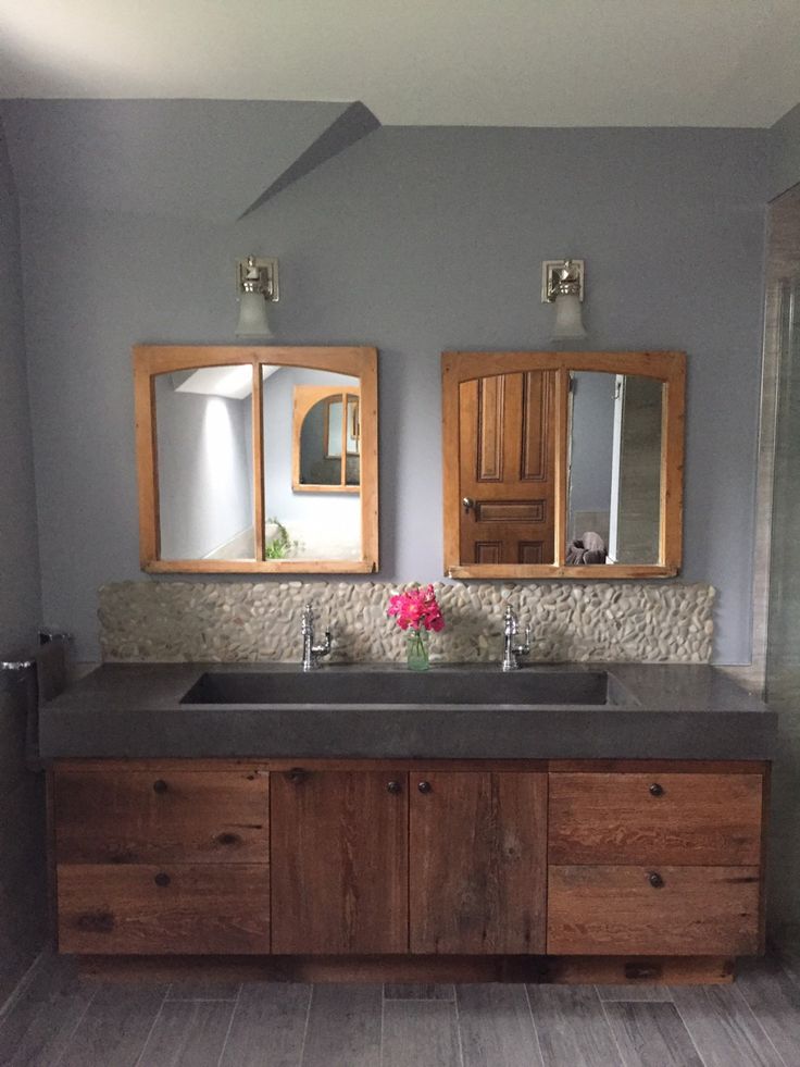 a bathroom with two sinks and mirrors on the wall