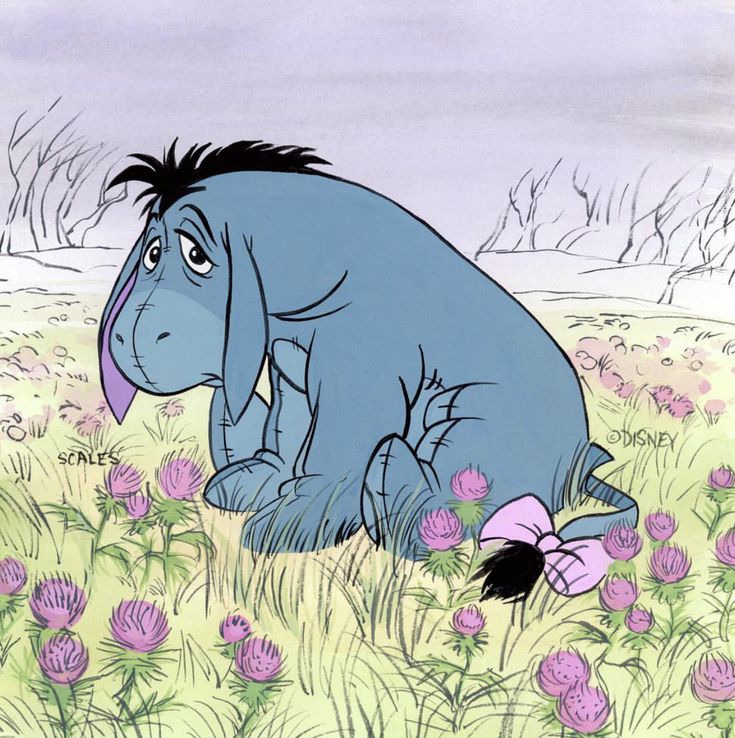 an elephant sitting in the middle of a field with flowers on it's side