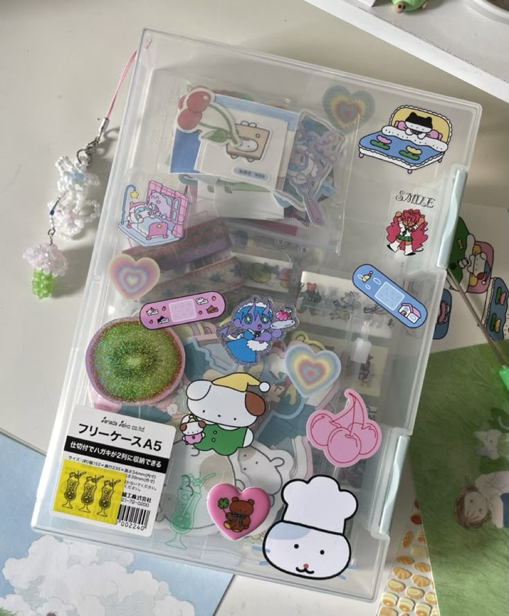 an assortment of stickers and magnets in a plastic container