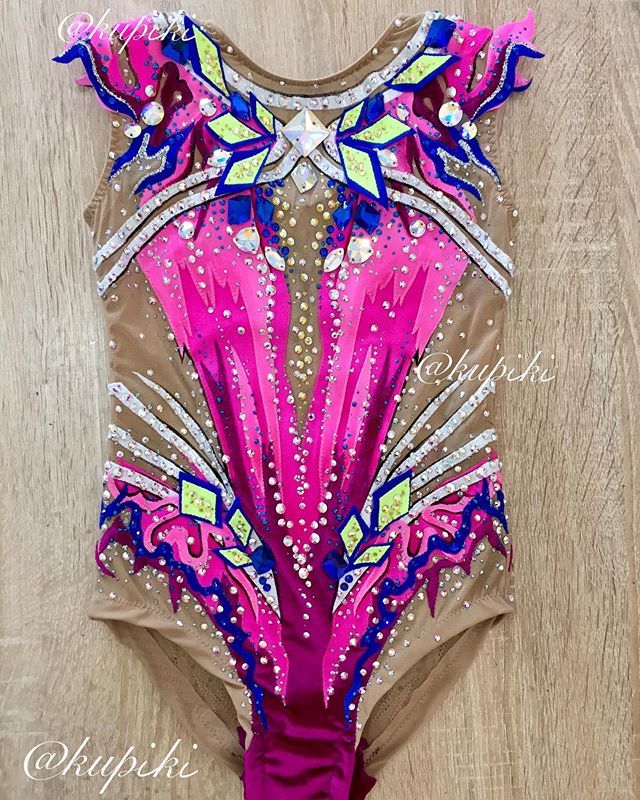 a woman's leotard with pink and blue designs on the side, in front of a wooden floor