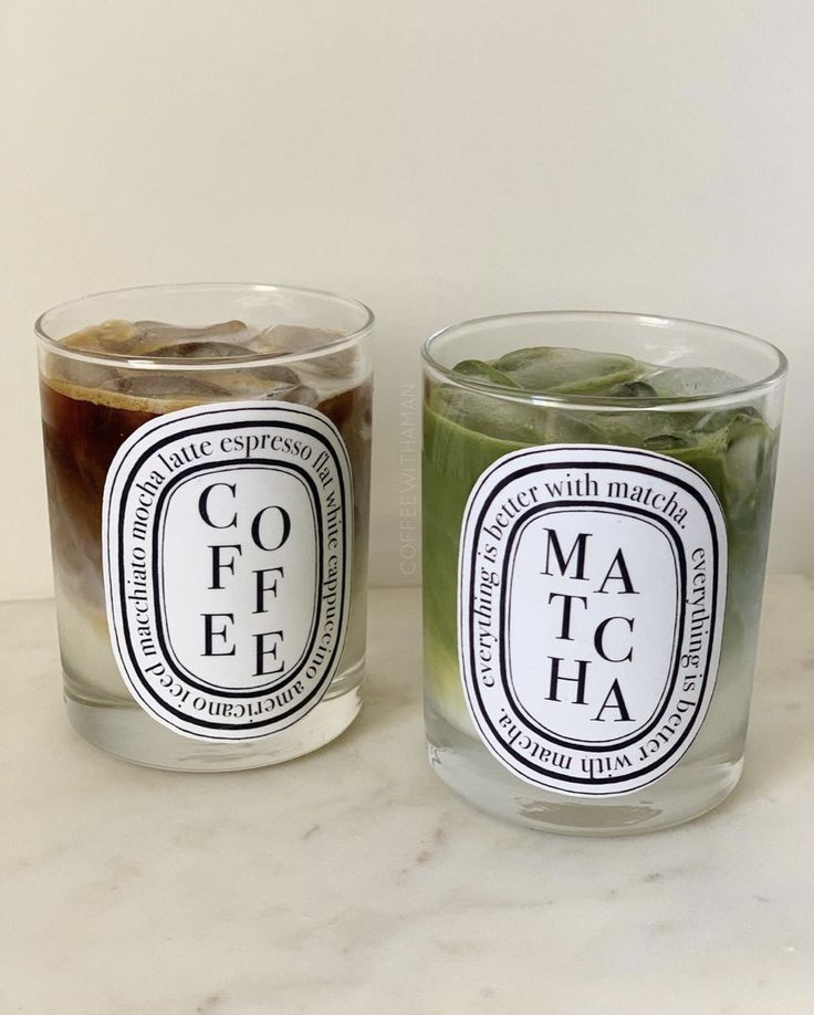 two candles with labels on them sitting next to each other