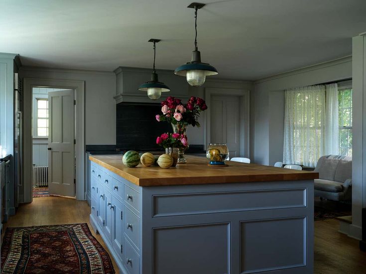 a kitchen island with flowers and fruit on it