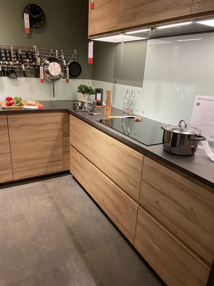 a kitchen with wooden cabinets and stainless steel appliances on the counter top, along with pots and pans