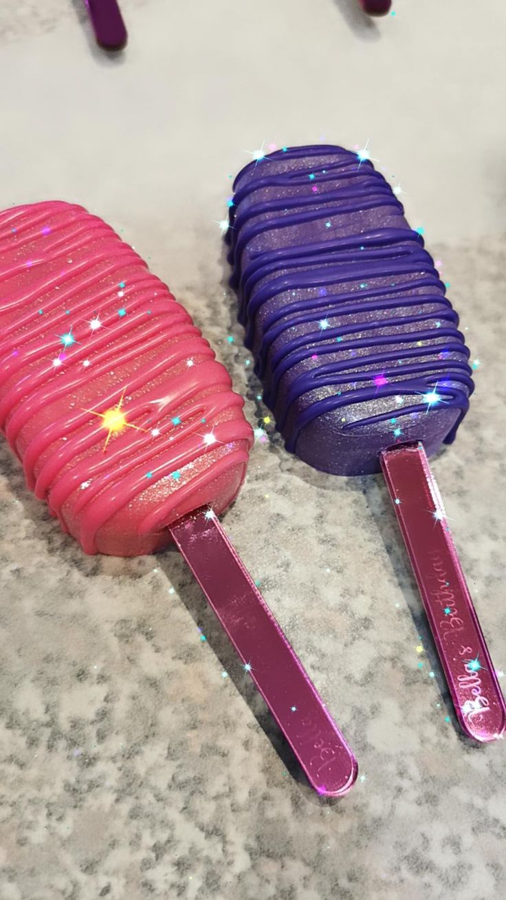 two purple and pink popsicles sitting on top of a counter