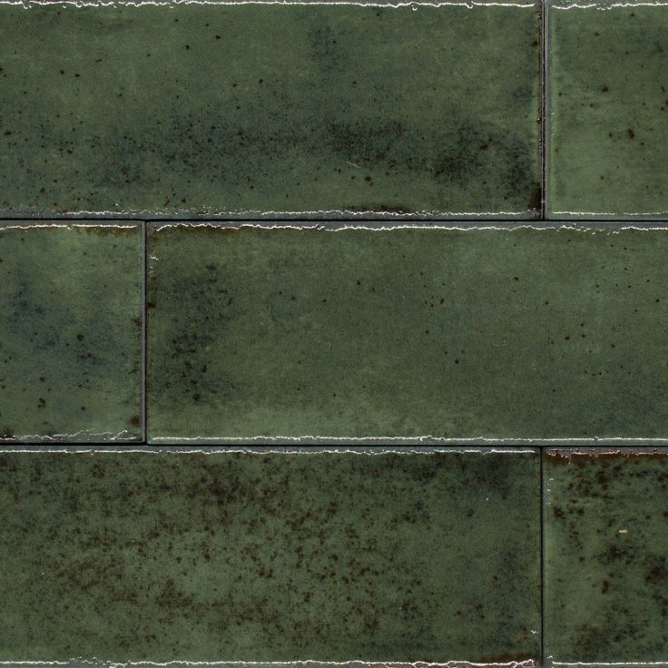 an old green brick wall with rust on it