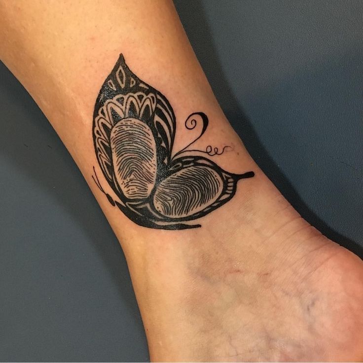 a black and white tattoo on the foot of a woman