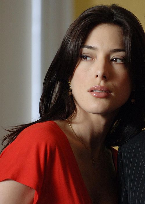 a woman in a red dress and a man in a black suit are posing for the camera