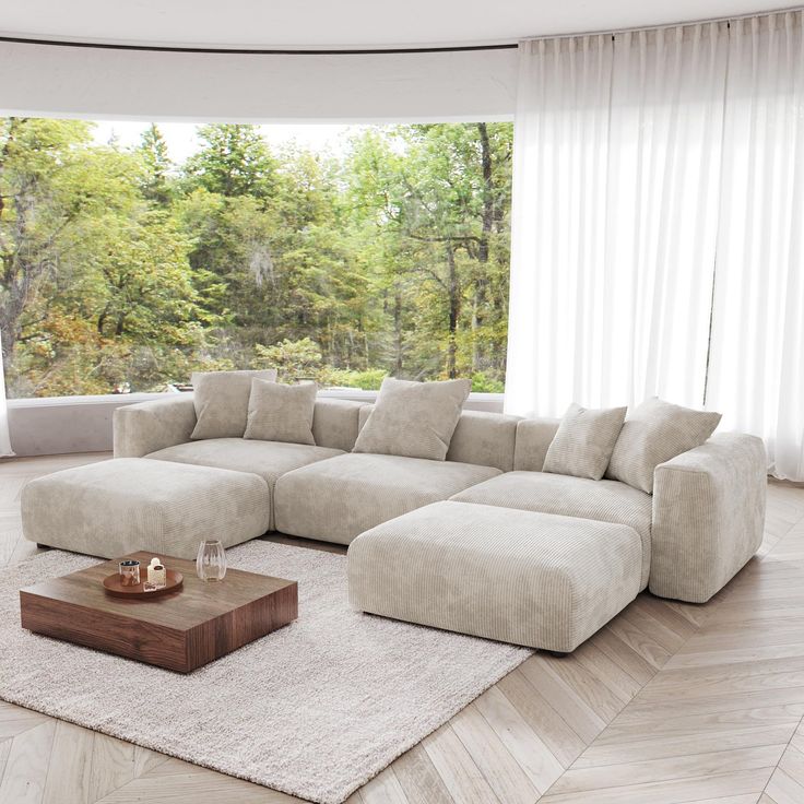 a living room with a large sectional couch and coffee table in front of the window