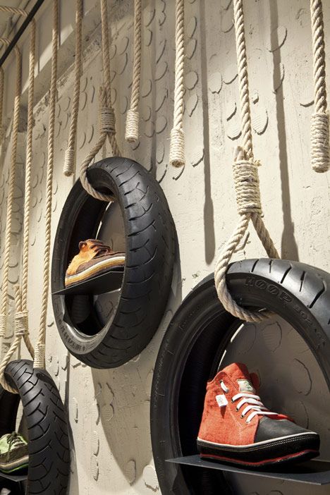 two tires are hanging on the wall with rope and shoes in them as if they were made from old tires