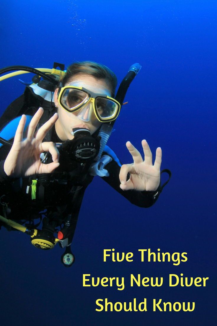 a woman scubas in the water with her hand up and saying five things every new diver should know