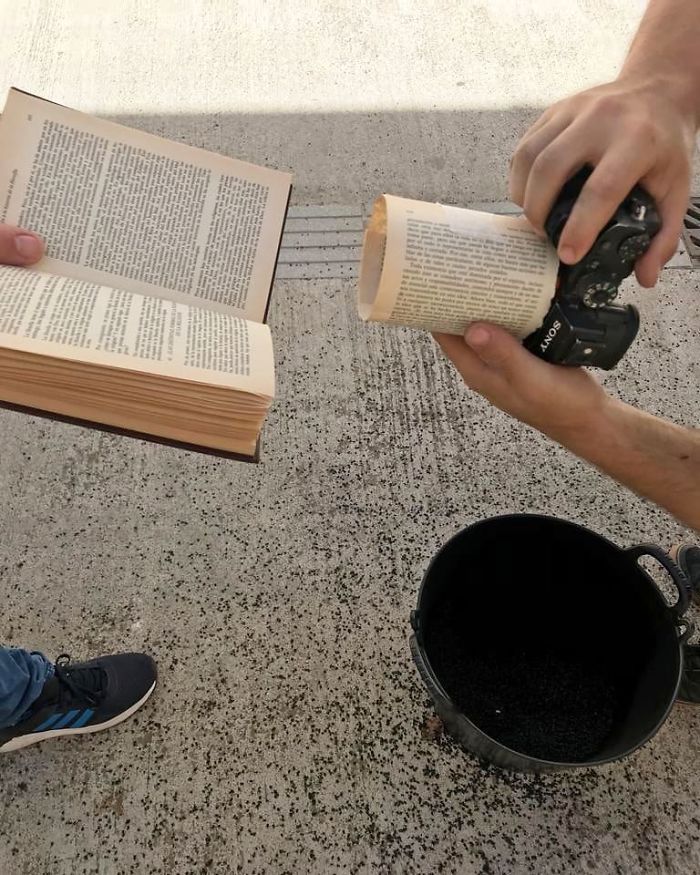 two people sitting on the ground reading books and drinking from mugs while one person holds an open book