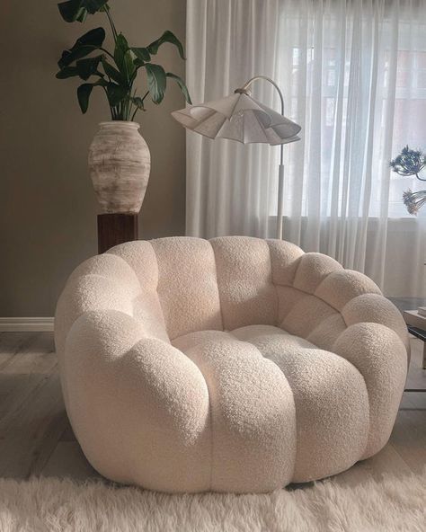 a large white chair sitting in front of a window