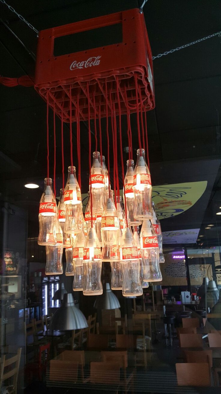 a chandelier made out of soda bottles hanging from the ceiling in a restaurant