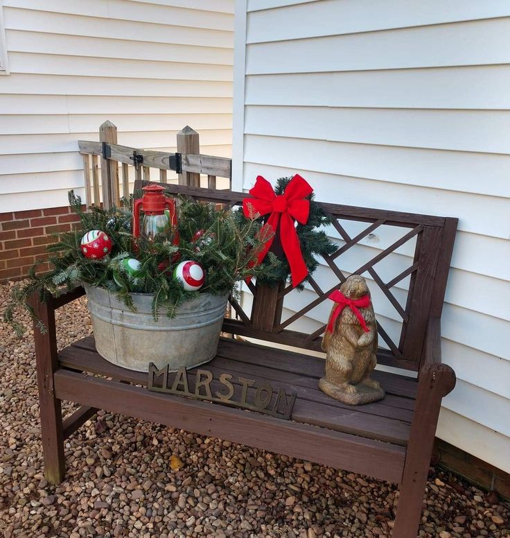 a potted plant sitting on top of a bench next to a wooden fence with christmas decorations