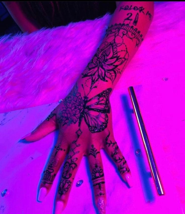 a woman's hand with tattoos on it next to a pair of scissors and a pen