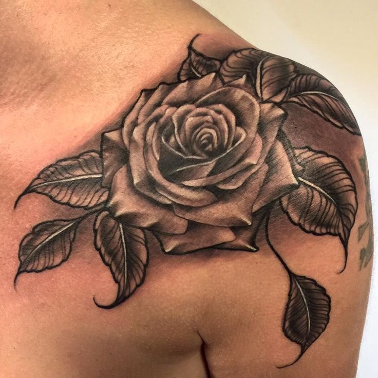 a black and white rose tattoo on the shoulder