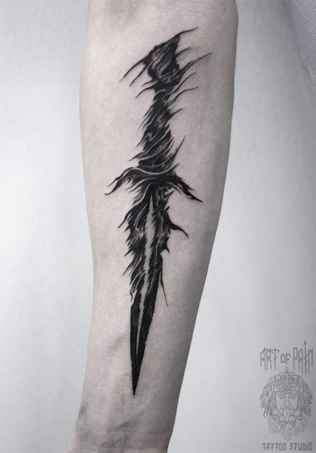 a black and white photo of a feather tattoo on the arm