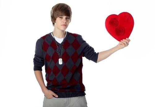 a young man holding up a heart shaped object