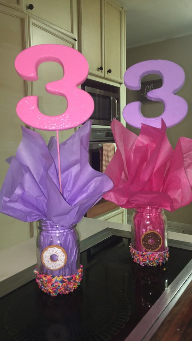 two vases filled with candy sitting on top of a counter