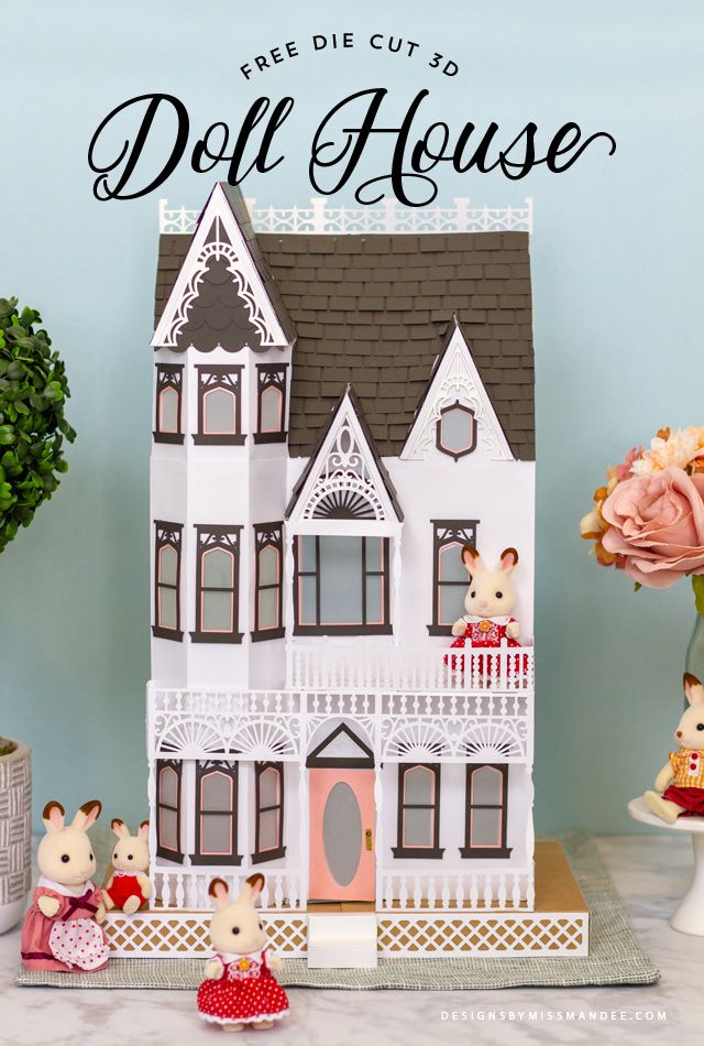 a paper doll house sitting on top of a table next to flowers and potted plants