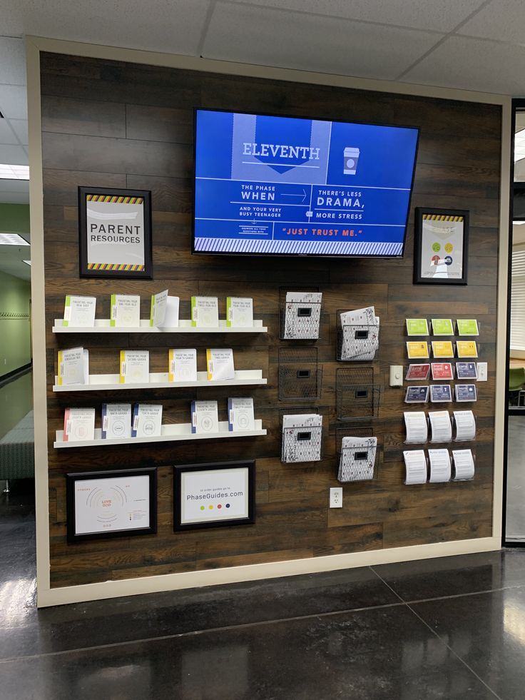 a wall with several different items on it and a television mounted to the wall above them