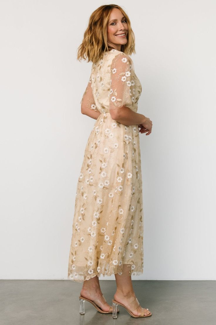 Baltic Born exclusive style Soft gold color with White floral appliques and Gold embroidery Tulle material draped over lining Round neckline Keyhole and button closure at back Sheer, double layered tulle sleeves Elastic back waist has stretch Maxi skirt and extra layer of tulle for more volume Fully lined excluding sleeves Marianne is 5'6, cup size 34D, size 6 and wearing size S Floral Embroidered White Dress, Gold White Dress, Flower Embroidered Dress, White Gold Dress, Embroidery Tulle, Mother Of Bride Outfits, Tulle Maxi Dress, Tulle Material, Maid Of Honour Dresses