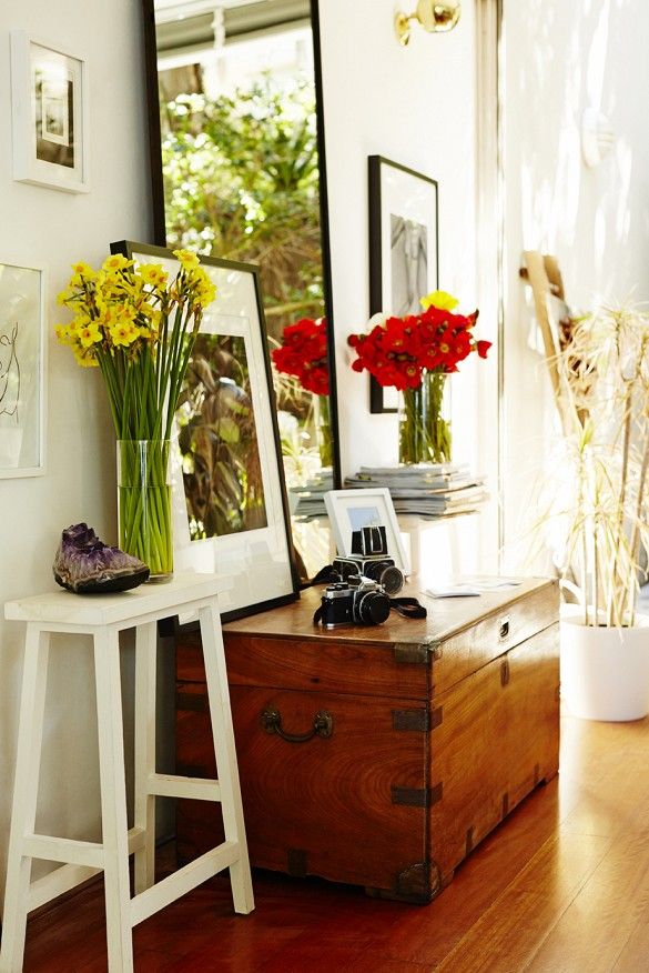 a wooden trunk sitting on top of a hard wood floor in front of a mirror