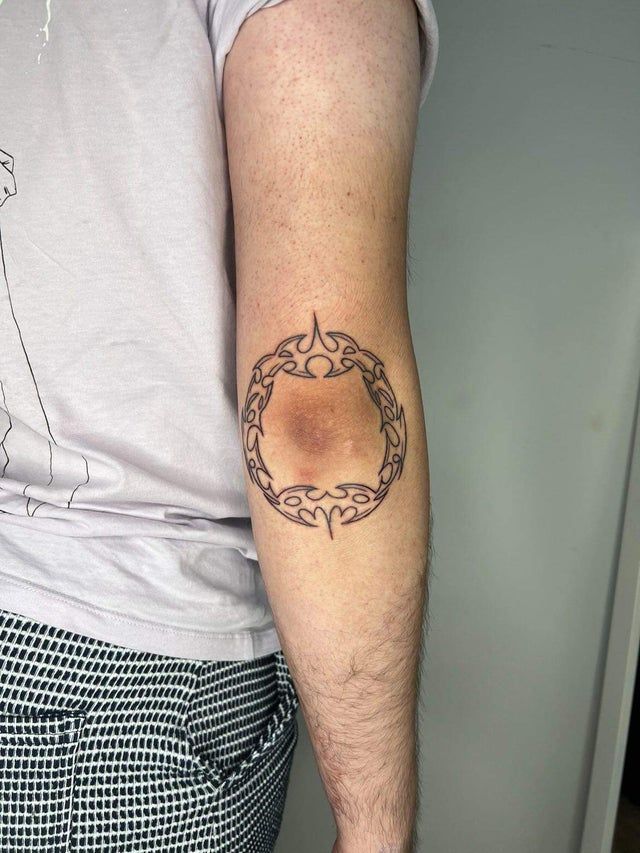 a man's arm with a tattoo on it that has a circular design in the middle