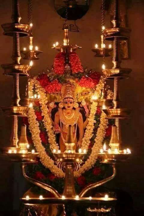 an idol is lit up with candles and flowers on the table in front of it