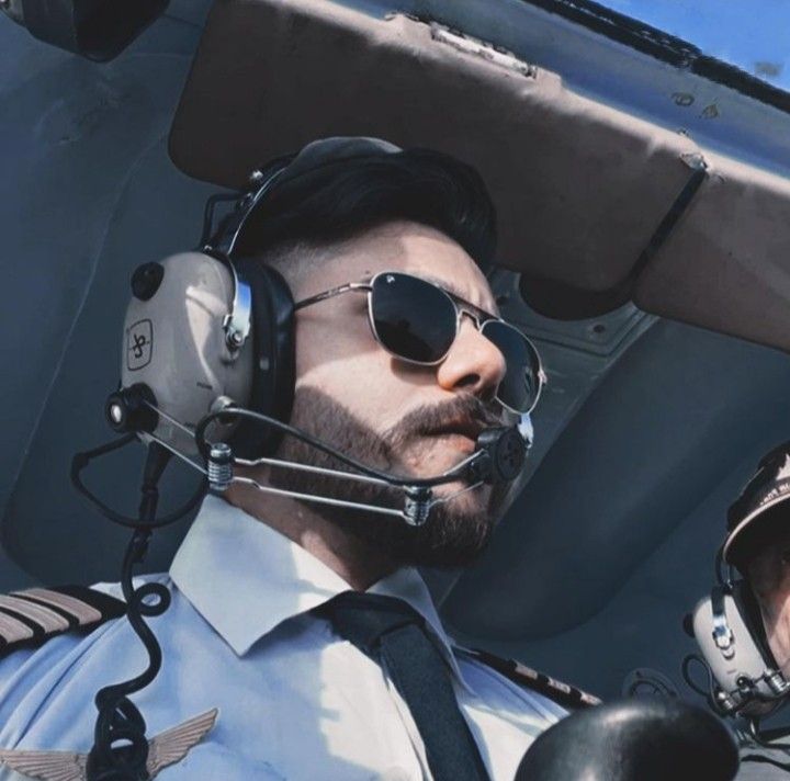 a man in pilot's gear wearing sunglasses and headphones