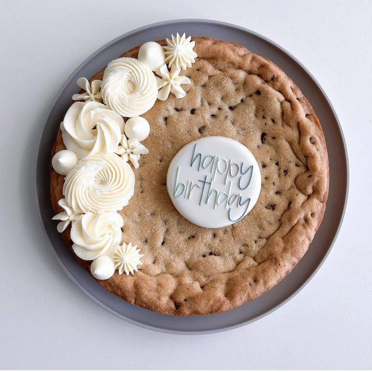 a cookie cake with white flowers and a button that says open my mouth on it