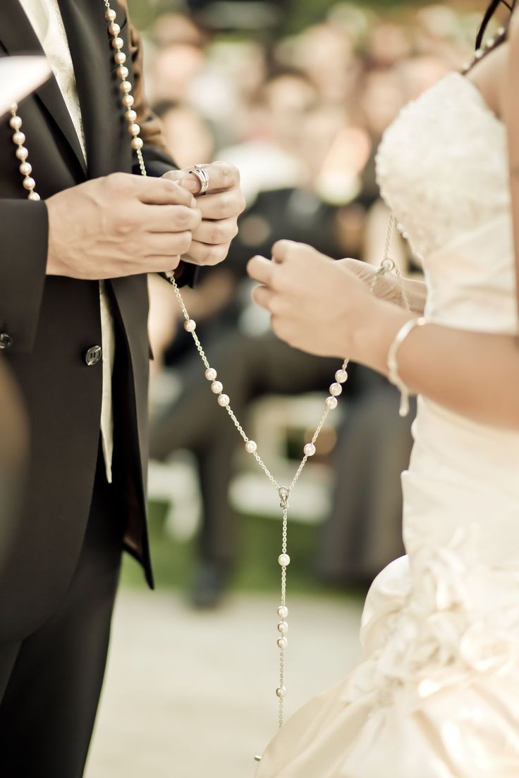 the bride and groom hold hands as they stand next to each other