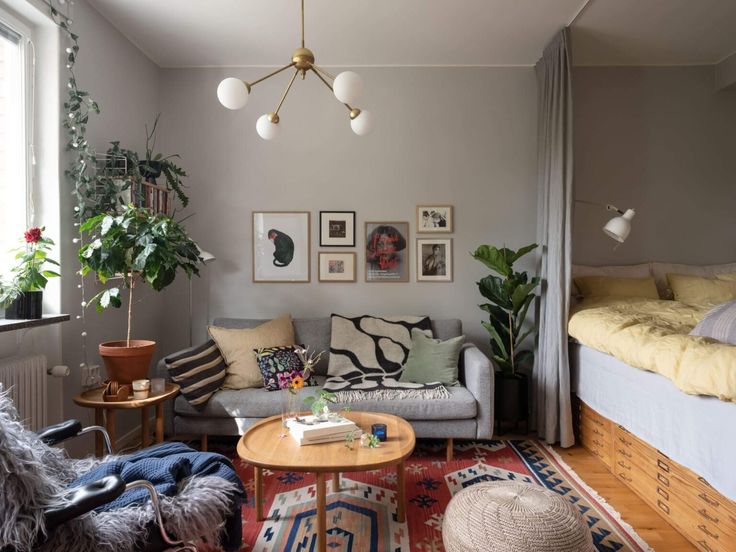 a living room filled with furniture next to a bed and a table in front of a window