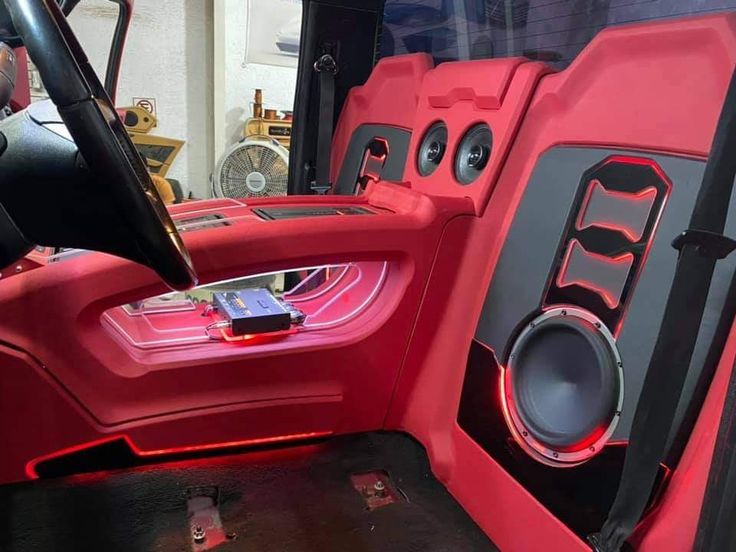 the interior of a red car with speakers