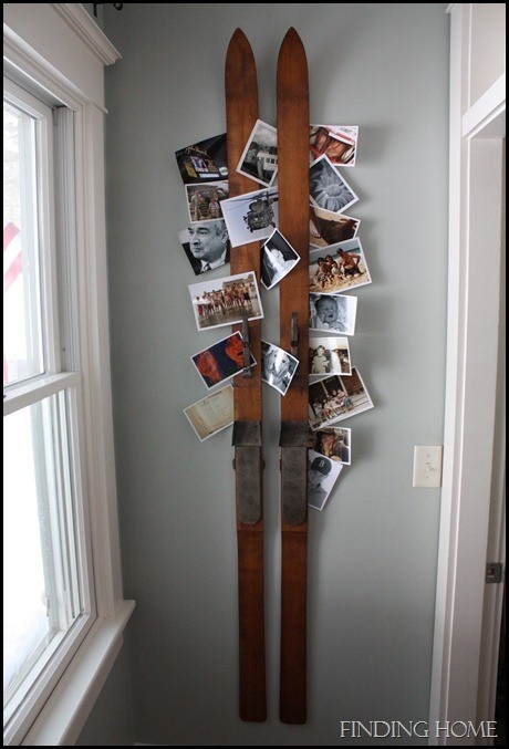 a wall mounted ski rack with pictures and photos on the bottom, hanging from it's sides