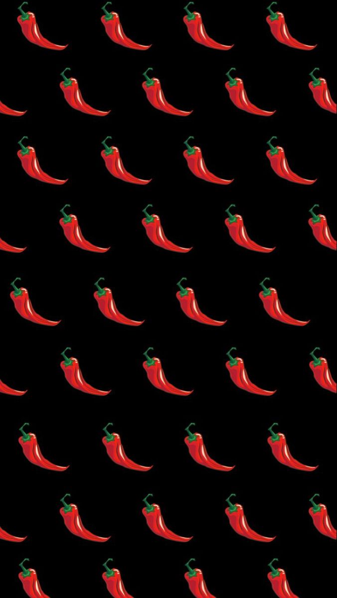 red peppers are arranged in rows on a black background, with green stems sticking out of them