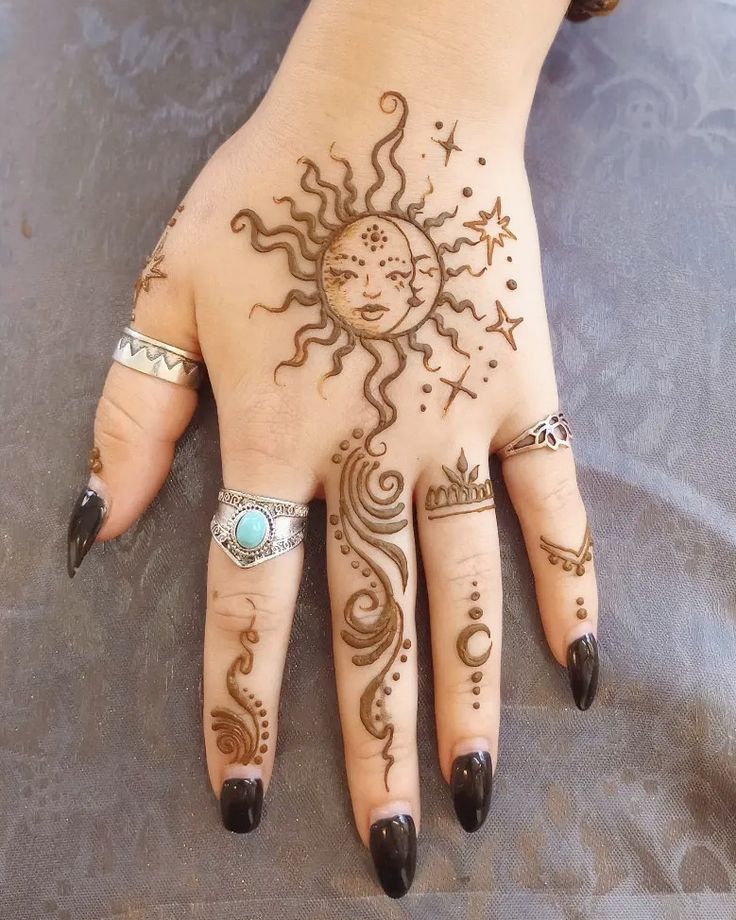 a woman's hand with henna tattoos on it