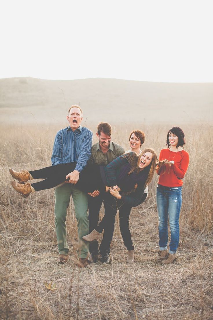 a group of people standing around each other in a field