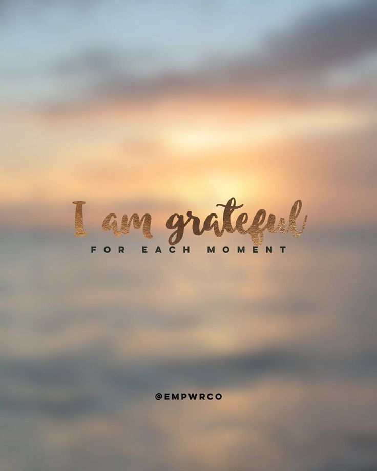 the words i am grateful are written in gold on a blurry background with an ocean view